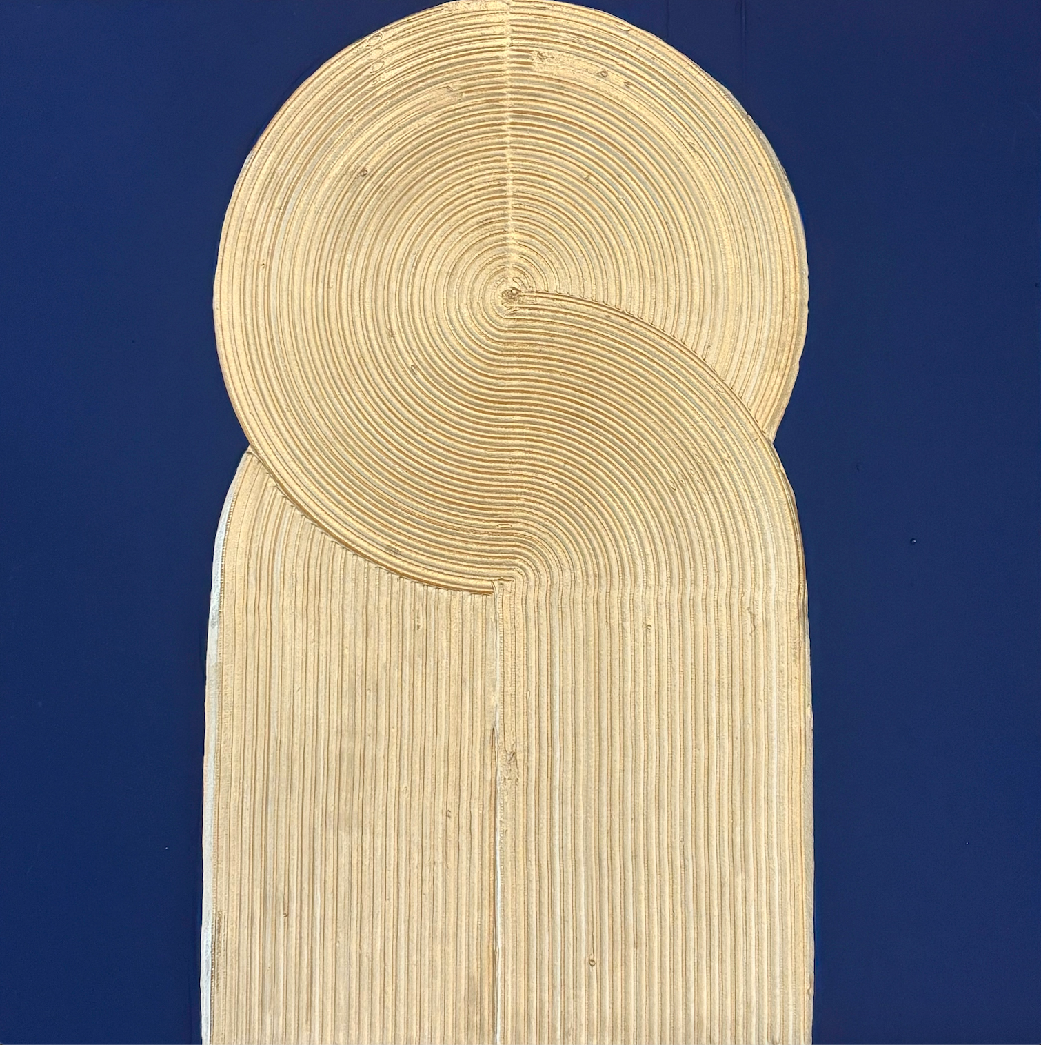 swirled circular golden pillar with line ridges texture on blue background