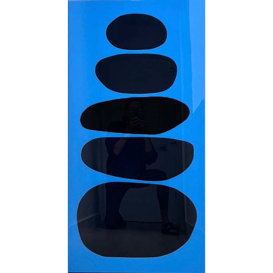 five black organic circular shapes in vertical composition stacked on top of each other, large at the bottom and smaller as they go up on blue background