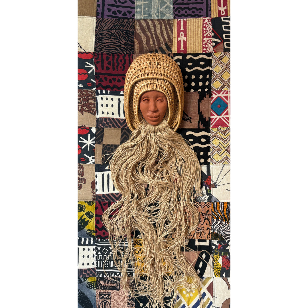 ceramic head portrait in woven basket and yarn coming out, against a background of quilted patterned fabric