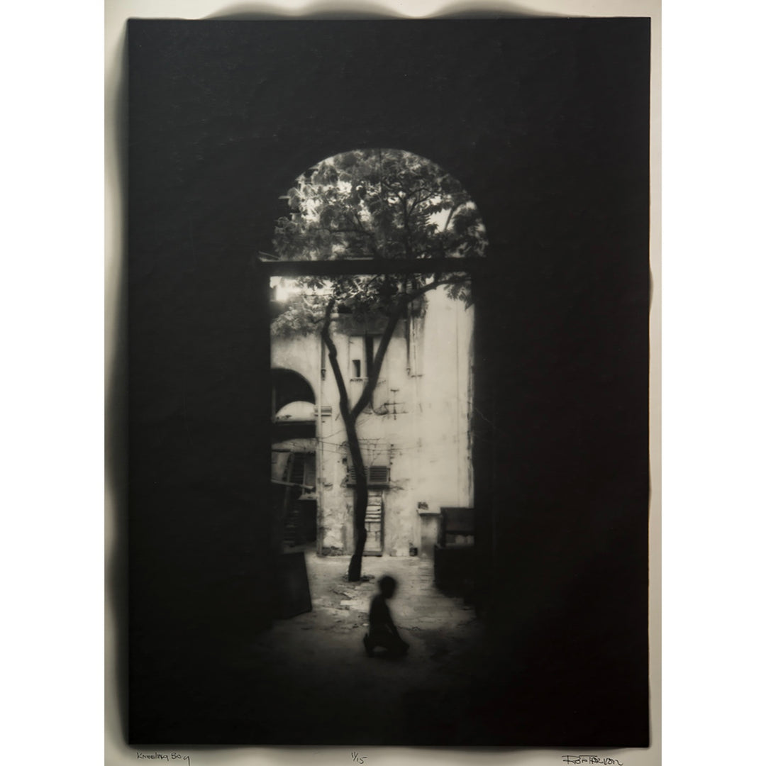 silhouette dark archway with figure boy kneeling in center and tree growing behind him, mostly all black with keyhole in center showing image