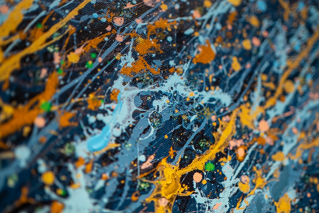 woman side profile face in black and white wearing gold headphones with sea scene flipping hair back in blue black and gold splatter paint on white background