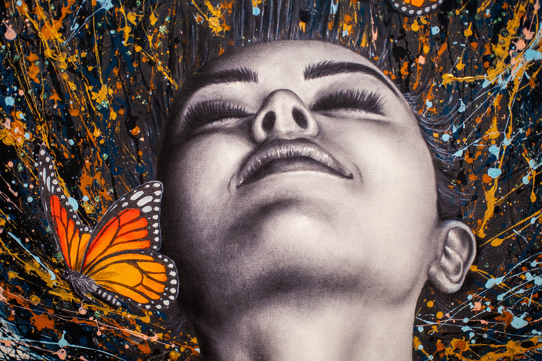 black and white woman flipping hair back with gold blue and black splatter paint, orange monarch butterflies in hair on white background