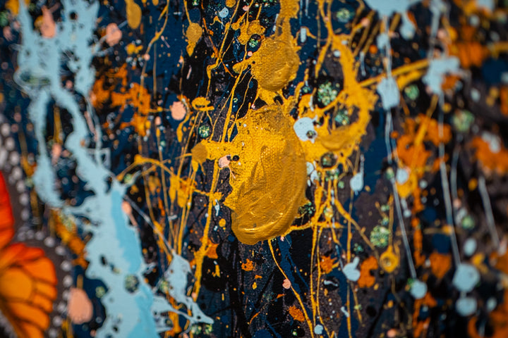 black and white woman flipping hair back with gold blue and black splatter paint, orange monarch butterflies in hair on white background
