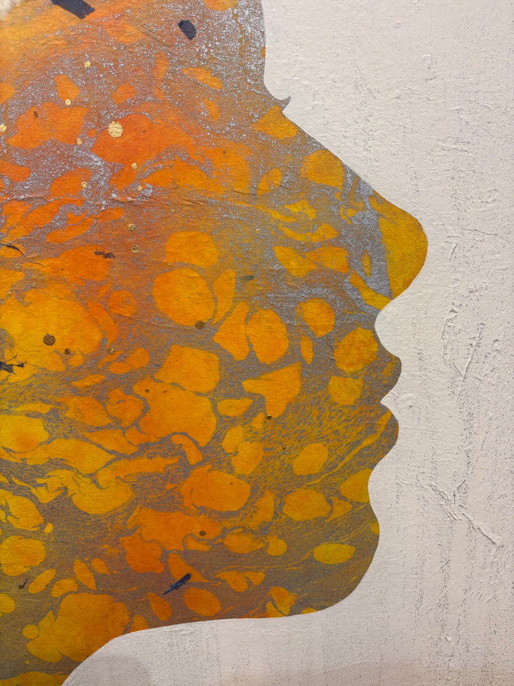 Detail shot of Born to Bloom by Christopher Peter — close-up of the face profile showing rich gold, amber, and orange acrylic paint with marbled silver texture on the canvas surface