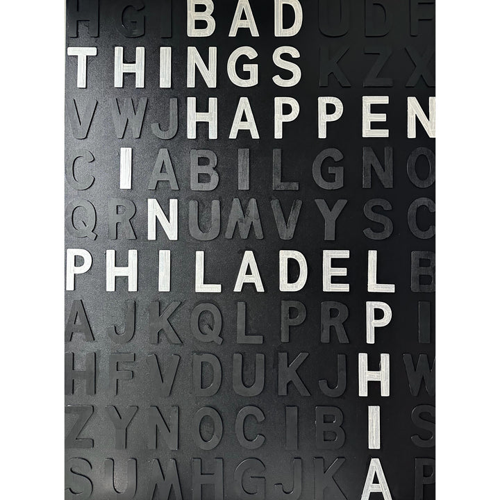 random black wooden letters are on a black canvas with white letters spelling out "Bad Things Happen In Philadelphia" mixed throughout.