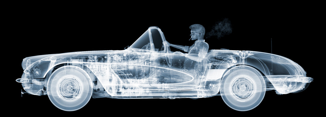 Framed Chromaluxe black and white x-ray photograph by Nick Veasey of a skelton man driving a vintage corvette cruiser while spoking a cigarette