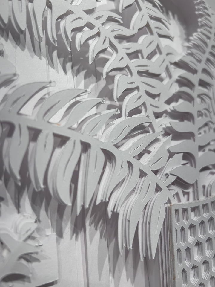 14"x14" layered white paper forming a vase with a fern over a wall.  