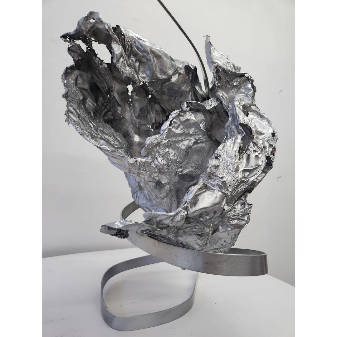 metal sculpture organic abstract shape with holes wrinkles and spiral stand in silver