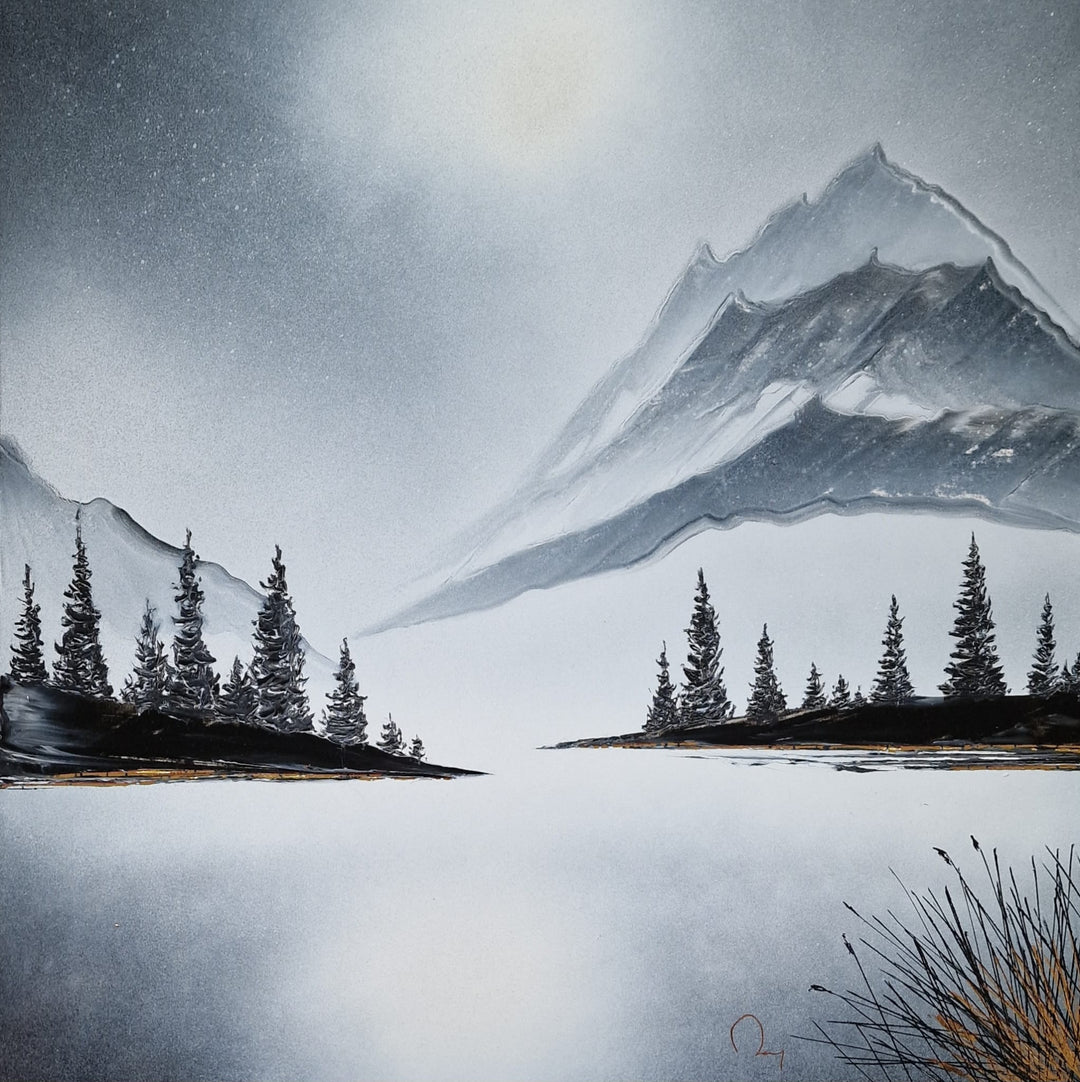 "Entre Lac et Montagne" by French artist Julien Rey — a mixed-media painting on board of an alpine winter landscape, crafted with Chinese lacquer and gold leaf. A vast frozen lake stretches across the foreground, framed by silhouetted pine trees and dramatic snow-capped mountain peaks rising into a luminous silver-gray sky. Delicate gold leaf accents shimmer along the shoreline. Original contemporary alpine landscape painting on board available at Morton Contemporary gallery.
