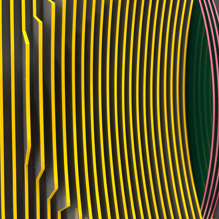 vertical stripes in black and yellow with circle in center offset optical illusion stripes with pink purple stripe down the middle