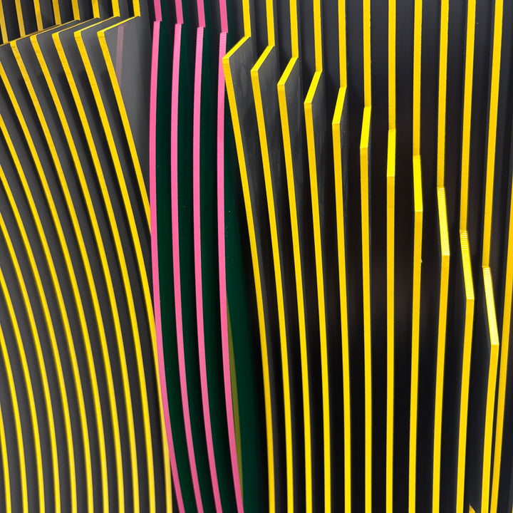 vertical stripes in black and yellow with circle in center offset optical illusion stripes with pink purple stripe down the middle