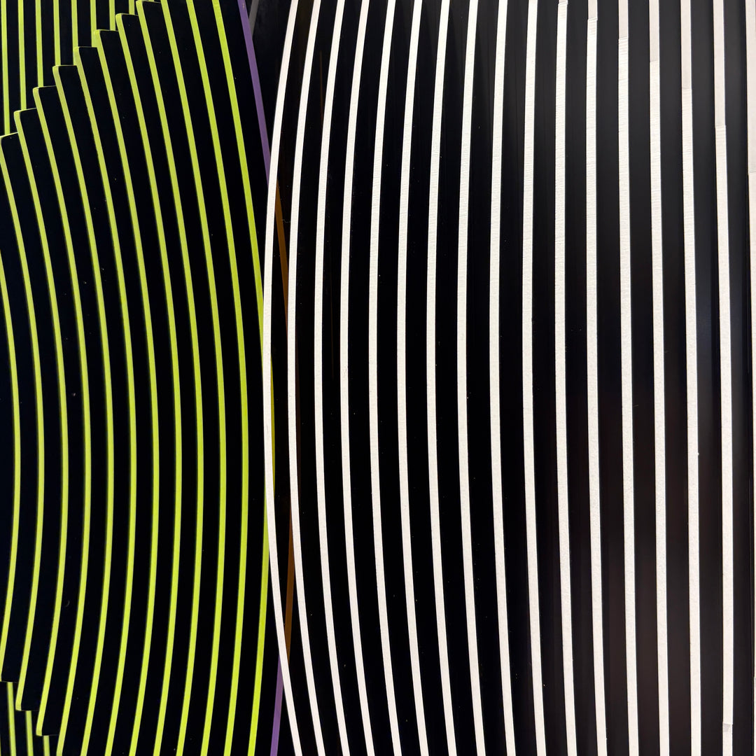 vertical stripes in black and yellow with circle in center offset optical illusion stripes with pink purple stripe down the middle