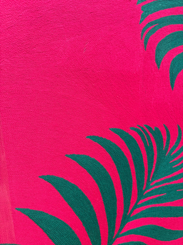 42.5"x42.5" chain-stitched textile with two tropical leafs over a bright pink background. 
