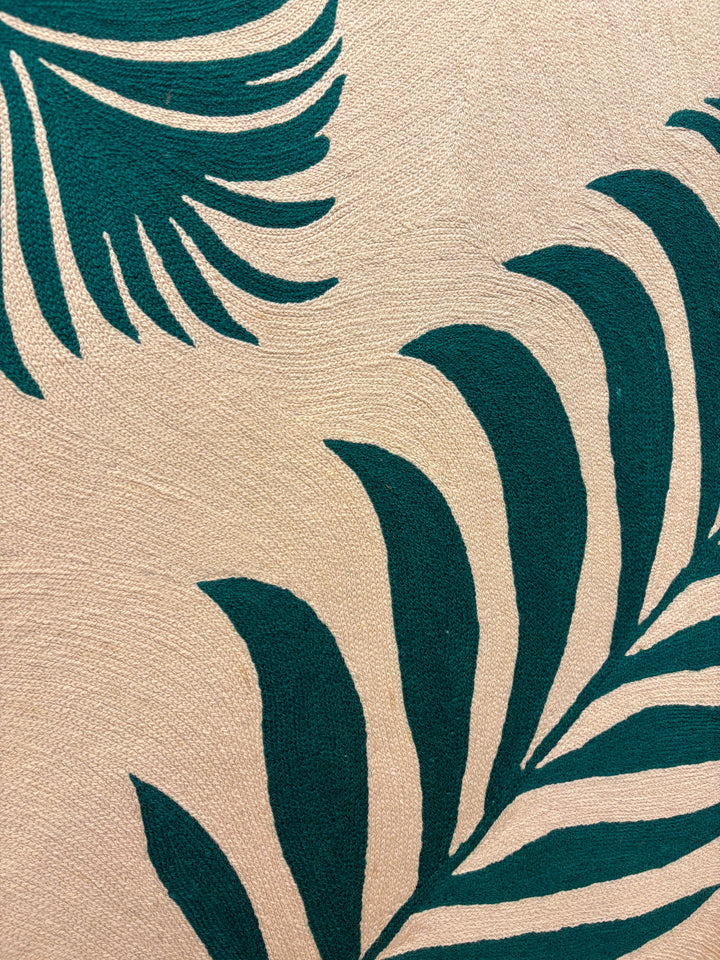 Two green palm fern leaves green on cream tan background in stitched embroidery chain textile fabric 