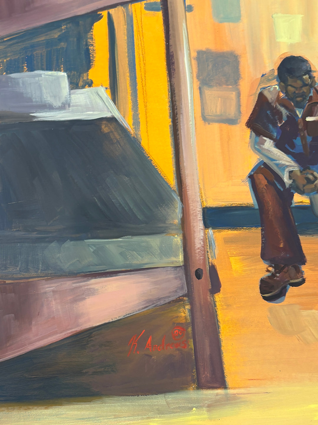 man sitting alone in empty prison cell with bed dresser in orange and brown tones