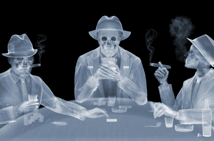 Framed Chromaluxe black and white x-ray photograph by Nick Veasey of three skeletal figures in fedoras and suits playing poker at a table and smoking cigars and holding drinks.