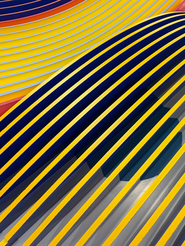 Porthole 440 by José Margulis – curved detail of the navy, yellow, orange, and teal plexiglass strip layers