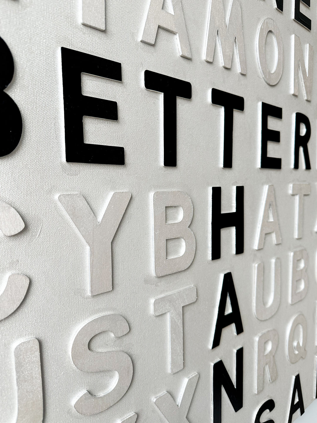 Contemporary 3D text artwork by Chicago artist Steffanie Gerkin titled Well Done 3D, featuring raised black and white wood letters arranged in a structured alphabet grid on a white canvas. The monochrome typographic composition spells the phrase “Well Done Is Better Than Well Said,” creating a bold conceptual wall art piece with graphic text-based design, pop art influence, and contemporary mixed-media style.