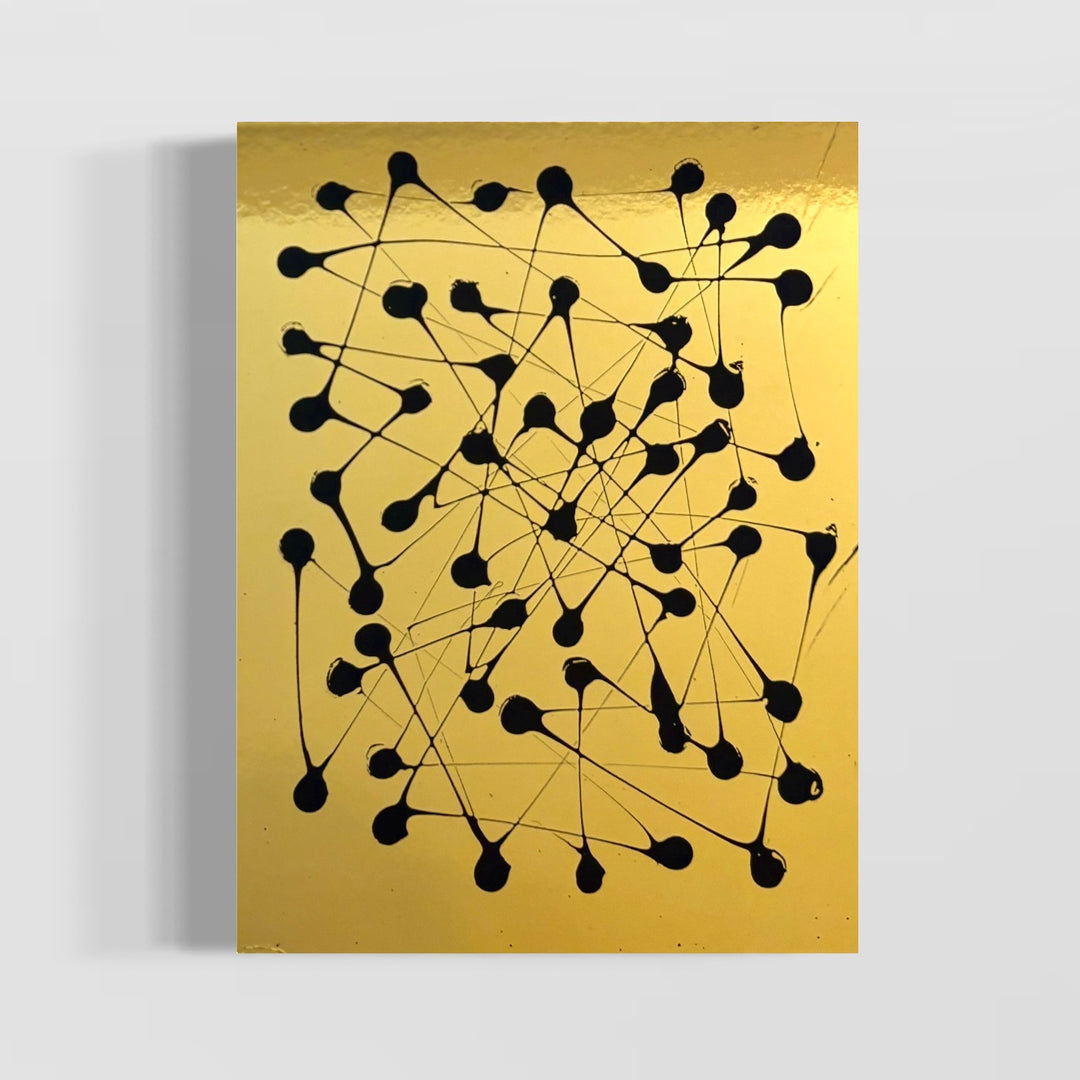 abstract expressionistic pointillism of black paint dots on smooth shiny reflective gold surface by m clark