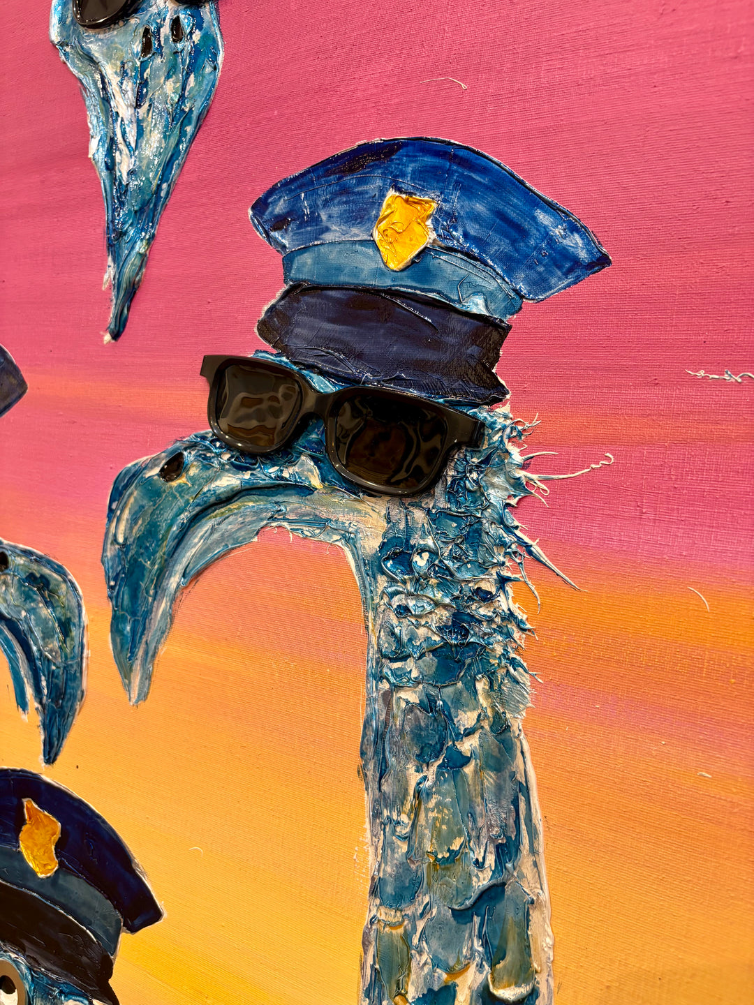 48" x 48" acrylic on canvas painting of blue birds with hats and eyes made of washers over a pink and yellow gradient background. 