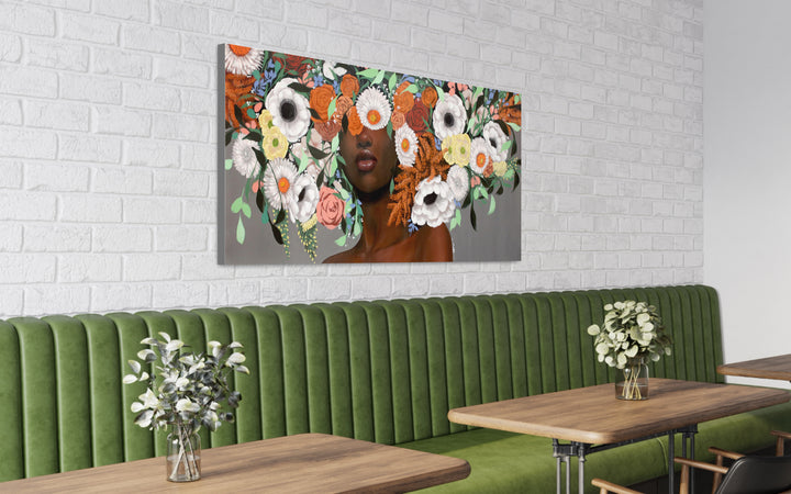 Oseye, artwork by Sally K., displayed on a wall behind a green bench.